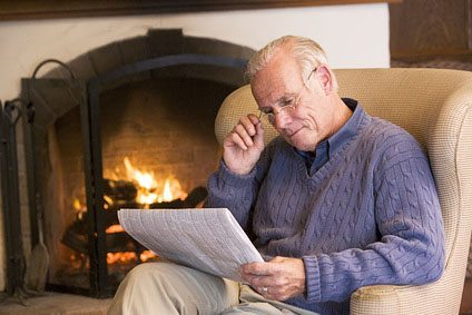 Man in chair by clean fireplace