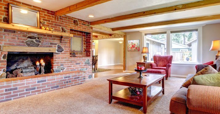 Living room interior with brick fireplace, wood beams and red.